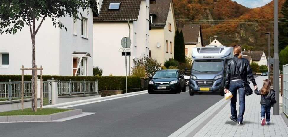 Visualisierung der fertiggestellten Straße Hohenrhein in Lahnstein: In der Mitte des Bildes die Straße unter blauem Himmel, auf der ein Wohnmobil fährt, links Häuser und rechts Fußgänger