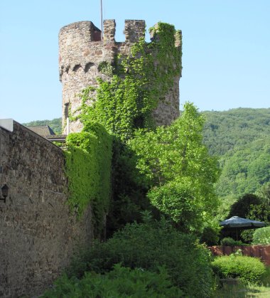 Historischer Wehrturm der Stadtmauer in Lahnstein, teilweise bewachsen mit grünen Blättern