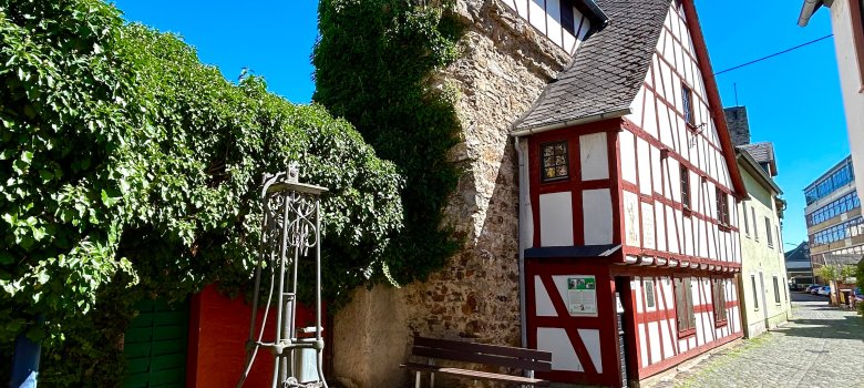 Fachwerkhaus in rot und weiß, das in die Stadtmauer angebaut ist