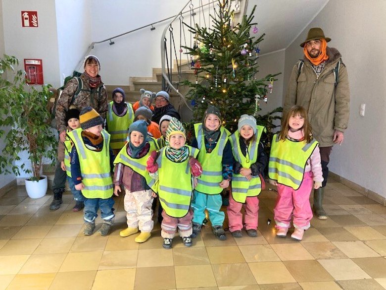 Kita-Kinder bringen Weihnachtsstimmung in die städtischen Verwaltungsgebäude Eine Gruppe von Kindern des Waldkindergartens Lahnstein steht mit gelben Warnwesten gekleidet zusammen mit einer Erzieherin und einem Erzieher vor dem von ihnen mit Selbstgebasteltem geschmückten Weihnachtsbaum im Foyer des Verwaltungsgebäudes in der Bahnhofstraße.