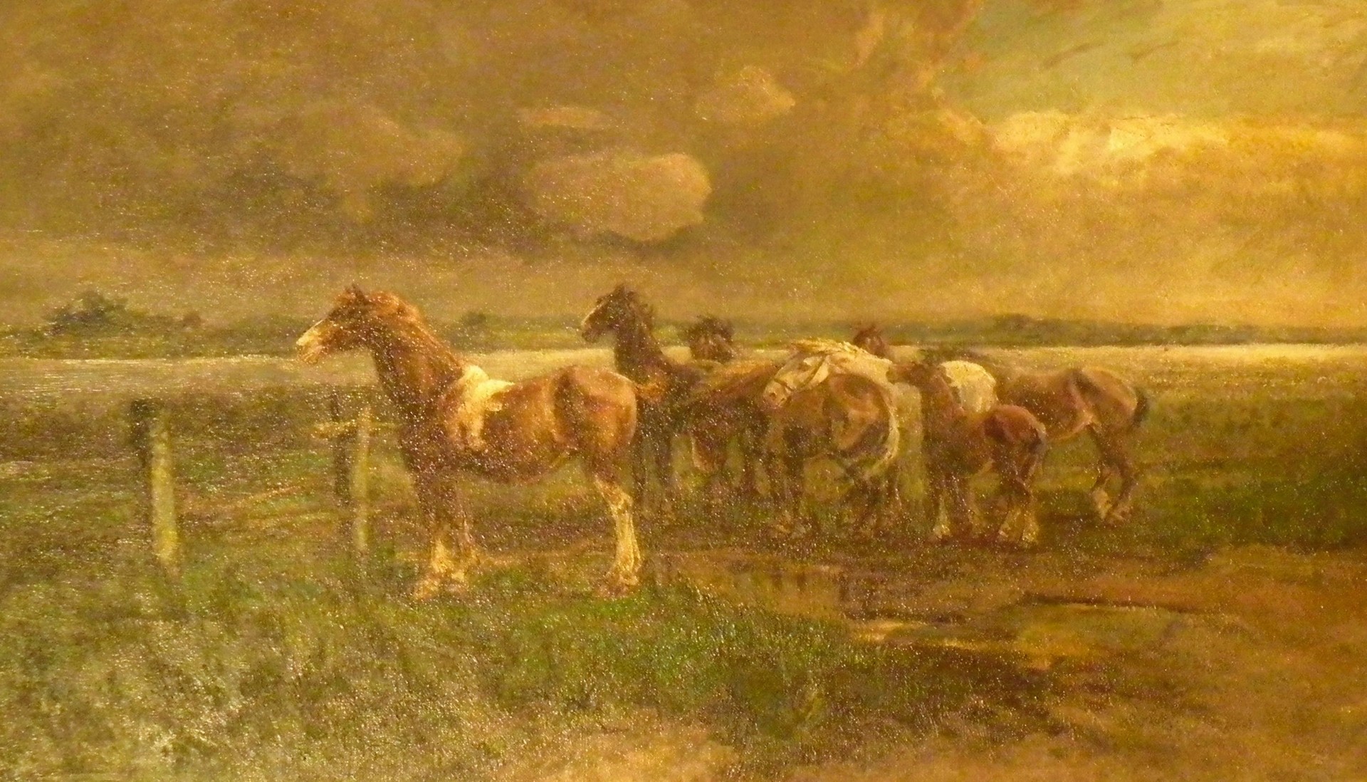 Gemälde in warmen Gold- und Brauntönen: Mehrere Pferde stehen und grasen auf einer umzäunten Weide unter dramatischem Himmel; im Hintergrund weite Landschaft.