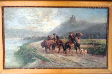 „Gemälde einer ländlichen Flusslandschaft: Zwei Männer reiten auf Pferden entlang eines Weges am Wasser, begleitet von einem kleinen Hund. Im Hintergrund liegt eine hügelige Landschaft mit einem Gebäude auf einem Hügel und einem Dorf am Ufer.“