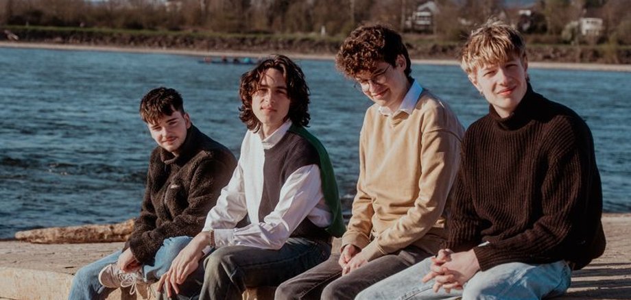 Die Band Herbstwind Die aus vier Musikern bestehende Band Herbstwind sitzt auf einer Mauer.