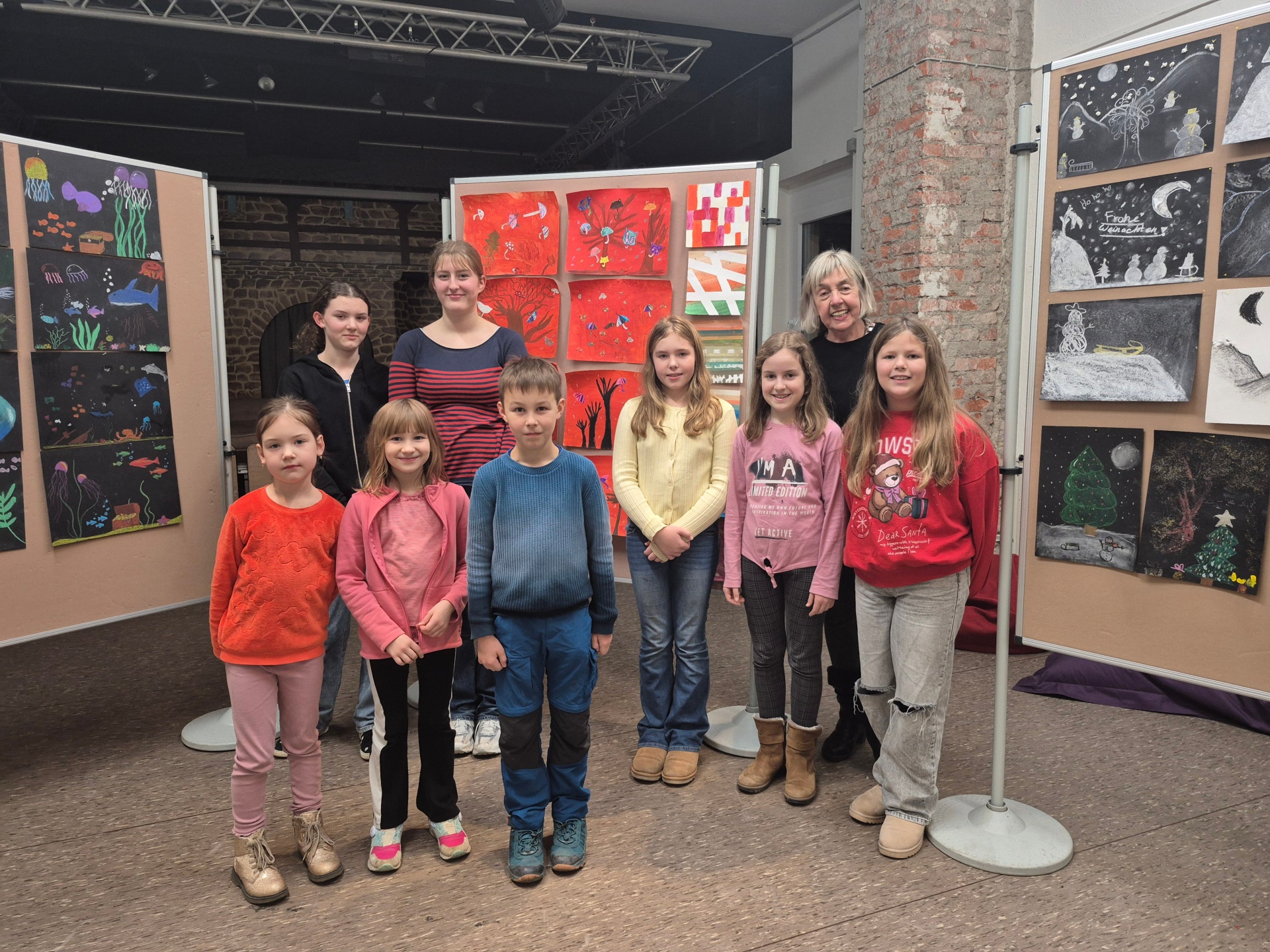 Eine Gruppe von Kindern, die an einem Malkurs des Jugendkulturzentrums teilgenommen hat, stellt ihre Werke auf Schautafeln aus.