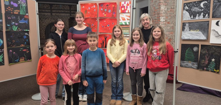 Eine Gruppe von Kindern, die an einem Malkurs des Jugendkulturzentrums teilgenommen hat, stellt ihre Werke auf Schautafeln aus.