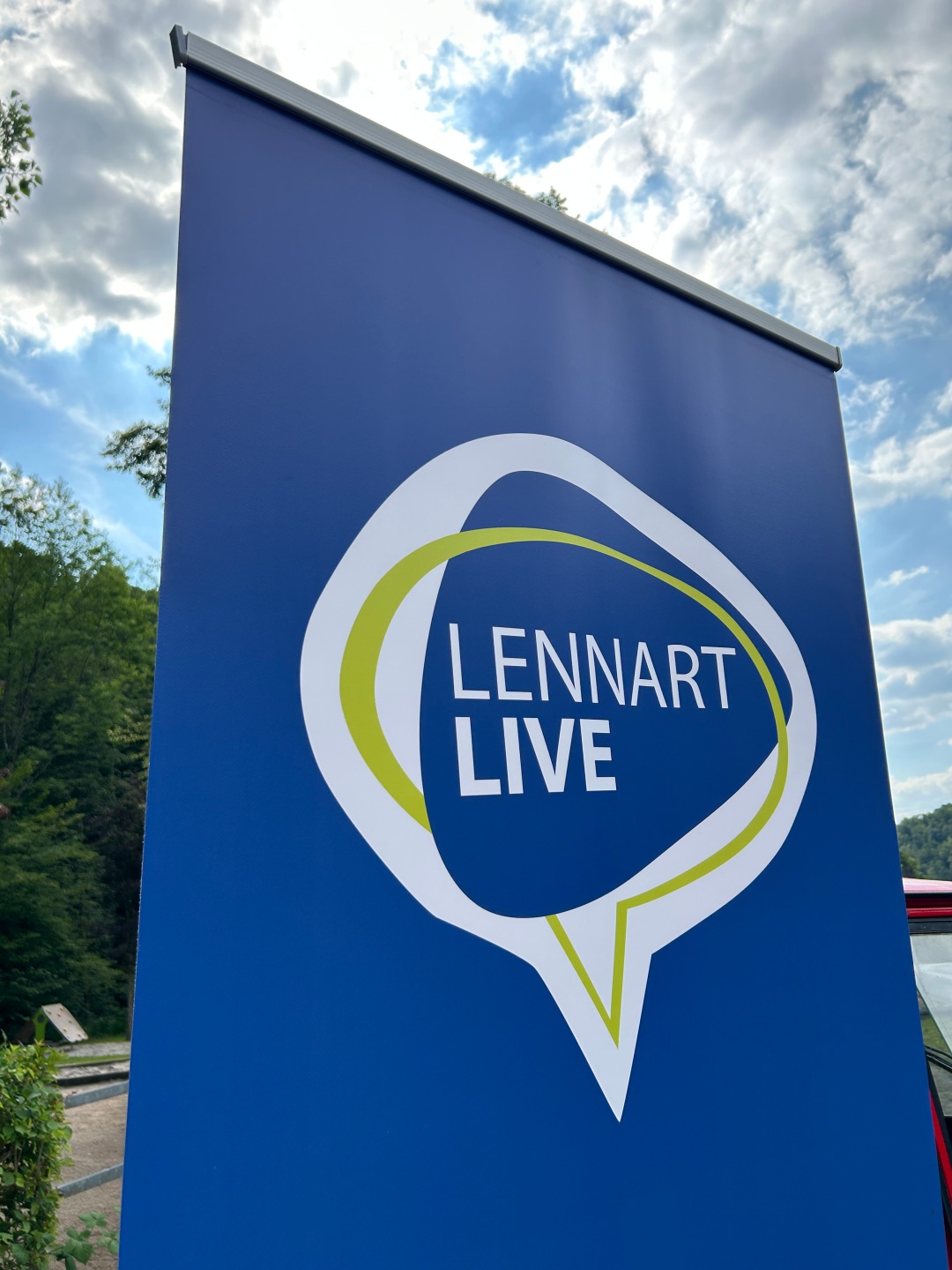 Blaues Banner vor blauem Himmel mit der Aufschrift Lennart Live in weiß