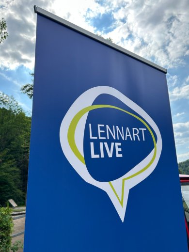 Blaues Banner vor blauem Himmel mit der Aufschrift Lennart Live in weiß