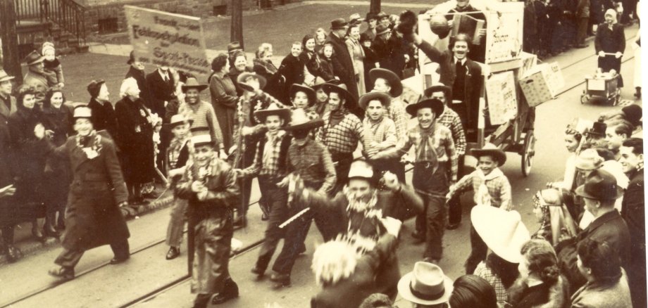 Eine Fotografie in Sepia mit einer Fußgruppe bei einem Karnevalsumzug in Niederlahnstein in den 1930er Jahren