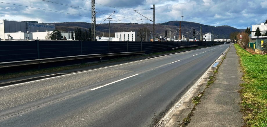 Lärmschutz an der Braubacher Straße geht in die Zielgerade Eine lange Straße, links ist eine Lärmschutzwand und rechts sieht man etwas Gehweg mit begrüntem Randstreifen erkennbar