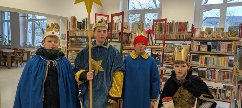 Sternsinger in der Stadtbücherei Vier Sternsinger in Verkleidung stehen in der Stadtbücherei Lahnstein.