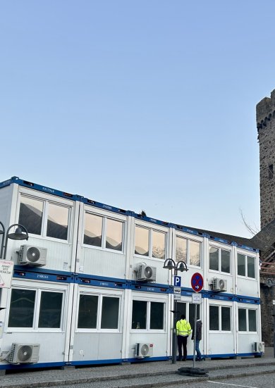 Mehrgeschossige Containeranlage mit jeweils vier Container, die durch eine Außentreppe verbunden sind auf dem Salhofplatz in Lahnstein vor der historischen Stadtmauer