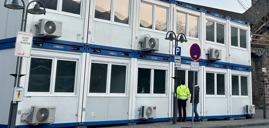 Mehrgeschossige Containeranlage mit jeweils vier Container, die durch eine Außentreppe verbunden sind auf dem Salhofplatz in Lahnstein vor der historischen Stadtmauer