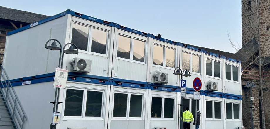 Mehrgeschossige Containeranlage mit jeweils vier Container, die durch eine Außentreppe verbunden sind auf dem Salhofplatz in Lahnstein vor der historischen Stadtmauer