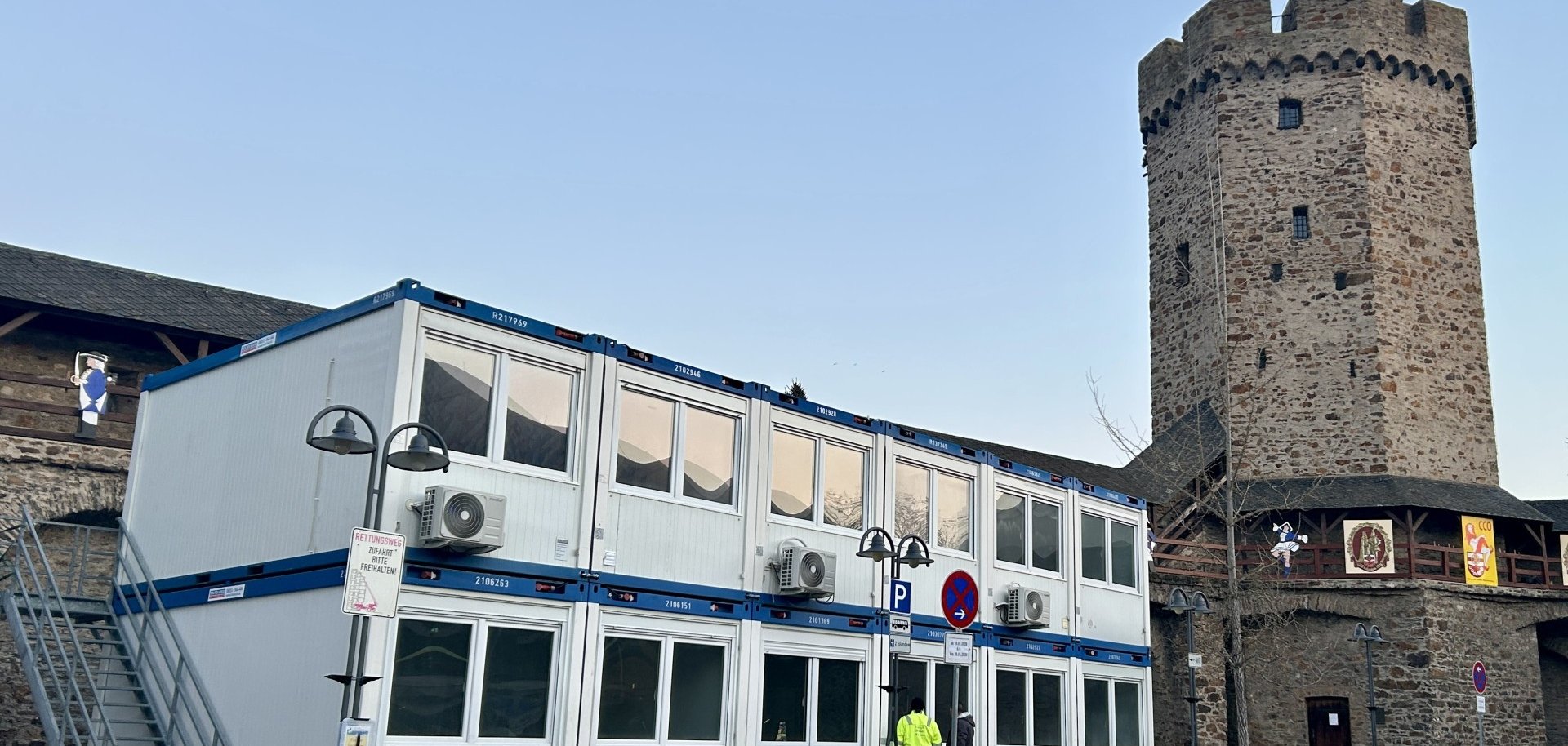 Mehrgeschossige Containeranlage mit jeweils vier Container, die durch eine Außentreppe verbunden sind auf dem Salhofplatz in Lahnstein vor der historischen Stadtmauer