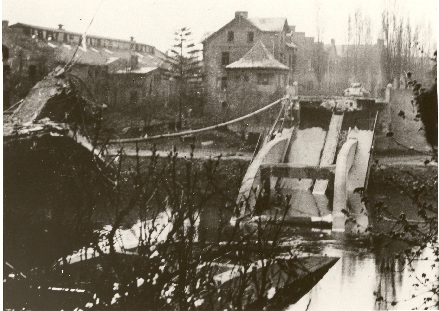 Schwarz-Weiß-Foto eines Panzers vor zerstörter Lahnbrücke