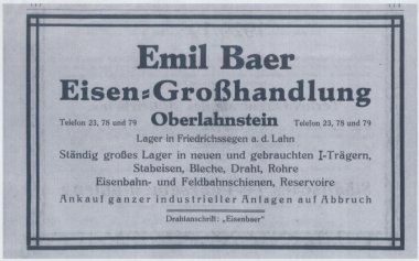 Anzeige aus Adressbuch 1926 Historische schwarz-weiße Werbeanzeige mit einem rechteckigen Rahmen. In großen Buchstaben steht oben „Emil Baer Eisen-Großhandlung Oberlahnstein“. Darunter folgen Angaben zu Telefonnummern und einem Lager in Friedrichssegen an der Lahn. Aufgeführt werden unter anderem I-Träger, Stabeisen, Bleche, Draht, Rohre, Eisenbahn- und Feldbahnschienen sowie Reservoire. Am unteren Rand steht „Ankauf ganzer industrieller Anlagen auf Abbruch“ und darunter „Drahtanschrift: ‚Eisenbaer‘“.