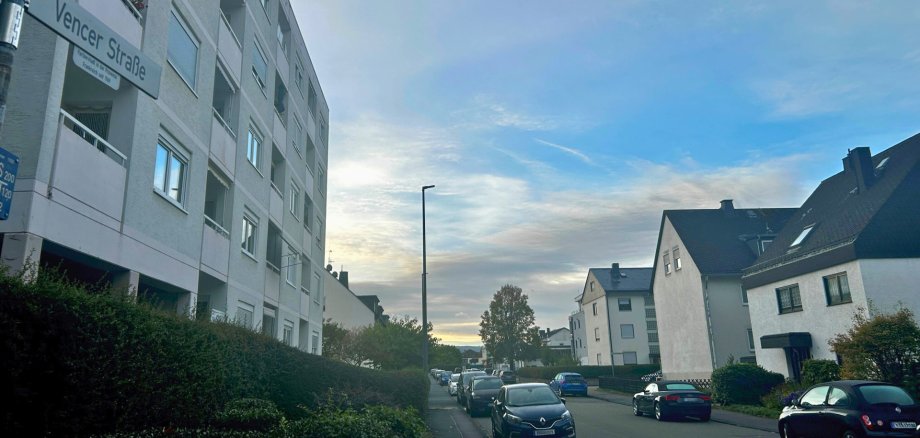 Vencer Straße Lahnstein Blick entlang der Vencer Straße in Lahnstein mit parkenden Autos auf beiden Straßenseiten. Links steht ein mehrgeschossiges Wohngebäude mit Balkonen, rechts befinden sich mehrere Wohnhäuser. Im Vordergrund ist das Straßenschild „Vencer Straße“ zu sehen.