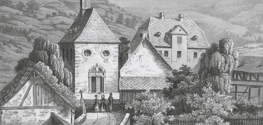 Spieß mit Kapelle, um 1850 Diese historische Schwarz-Weiß-Lithographie zeigt eine Ansicht von Ems, die sich auf ein Gebäudeensemble konzentriert. Links steht eine kleine Kapelle mit einem markanten Dachreiter und zwei Rundfenstern über dem Portal. Rechts daneben schließt sich das Mainzer Haus an, ein mehrstöckiges herrschaftliches Gebäude mit Walmdach. Im Vordergrund sind drei Personen in historischer Kleidung zu sehen, darunter eine Frau mit Sonnenschirm. Das Ensemble ist von Bäumen umgeben und liegt vor einem bewaldeten Hügel.