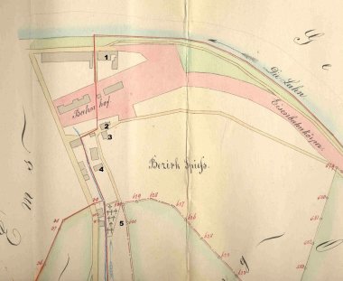 Lageplan von Spieß-Ems, 1872: Die rote Linie zeigt die alten Gemarkungsgrenzen, die rot-gestrichelte Linie die ab 1876 gültige neue Grenze zwischen Ems und Oberlahnstein Diese historische farbige Handzeichnung zeigt eine Landkarte, die den „Bezirk Spieß“ und das angrenzende Gebiet darstellt. Die Lahn ist am oberen Rand zu sehen, darunter der „Eisenbahnkörper“ und der „Bahnhof“. Mehrere Gebäude sind eingezeichnet und nummeriert. Eine gestrichelte rote Linie markiert die Gemarkungsgrenze. Die Karte ist mit handschriftlichen Ortsbezeichnungen und Grenzzahlen versehen.