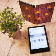 eBook-Sprechstunde in der Stadtbücherei Lahnstein Auf einem Tisch befinden sich ein geöffneter eBook-Reader, ein aufgestelltes Buch und eine Blume
