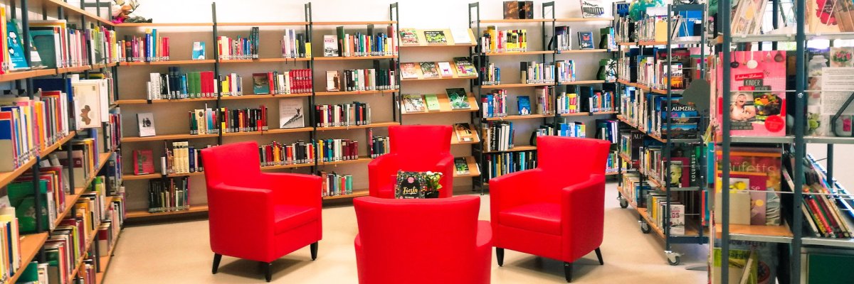 Innenraum der Stadtbücherei Lahnstein mit Bücherregalen, Tischen und gemütlichen Sitzgelegenheiten zum Lesen.