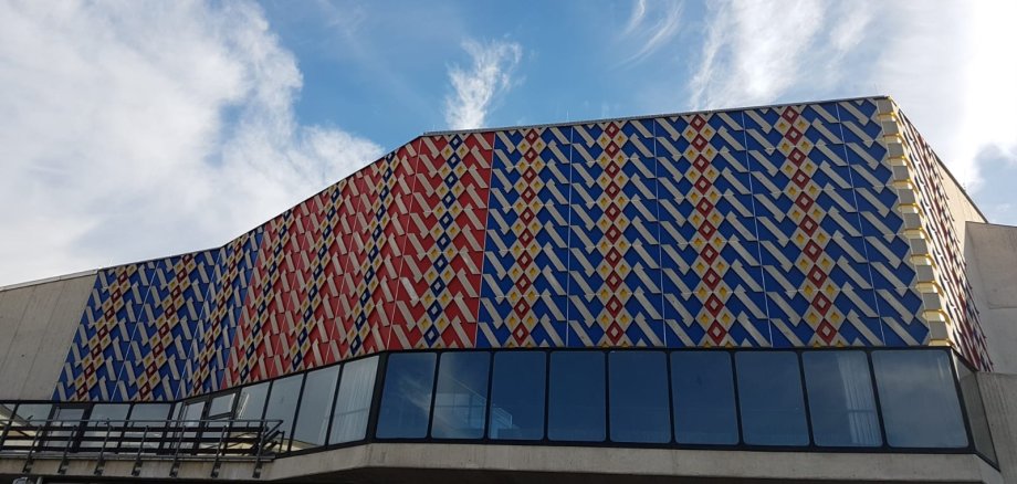 Auf der Außenfassade der Stadthalle Lahnstein ist der Teppichboden der Halle gezeigt 