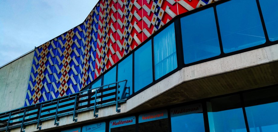Auf der Außenfassade der Stadthalle Lahnstein ist der Teppichboden der Halle gezeigt 