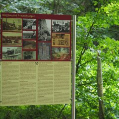 Hinweisschild mit Erläuterungen zum Bergbaupfad Grube Friedrichssegen Eine Informationstafel entlang des Bergbaupfades mit Texten und historischen Bildern.