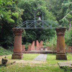 Bergbaupfad Lahnstein Friedrichssegen Ruine im Freien, die von zwei markanten Pfeilern und einer darüber liegenden Metallkonstruktion eingerahmt wird.