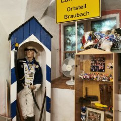CCO-Fastnachtsmuseum in Schloss Martinsburg Lahnstein Lebensgroße Schaufensterpuppe in historischer Uniform in einer Vitrine. Daneben befinden sich weitere Ausstellungsstücke und eine kleine hölzerne Präsentationsvitrine.