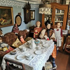 Nachbildung der Lebensverhältnisse im 19. Jahrhundert im Stadtmauerhäuschen Lahnstein Innenansicht eines historisch eingerichteten Zimmers im Stadtmauerhäuschen mit einem gedeckten Tisch und historisch gekleideten Schaufensterpuppen, die an einem Tisch sitzen.